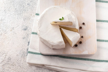 Wooden board with brie cheese. Italian antipasti snacks. French camembert cheese.