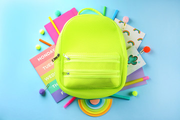 Hipster neon green textile backpack, surrounded with school supplies. Back to school concept. Lots...
