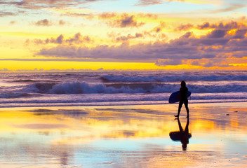 Fototapeta na wymiar surfer walking sunset Bali beach