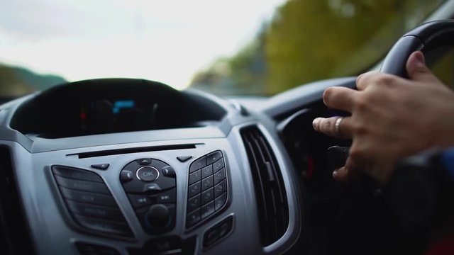 Male driver driving a car with a left-hand steering wheel in the country with left-hand traffic. Close up. Cyprus.
