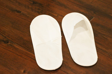 White slipper on the floor of hotel room.