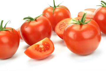 Group of whole and sliced tomatoes isolated on a white background in close-up