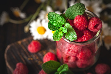 Raspberries in a Cup on a dark background. Summer and healthy food concept. Selective focus. Vertical.