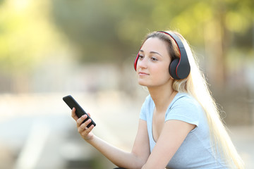 Relaxed girl listening to music with headphones and phone