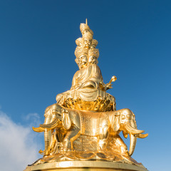 gold buddha against a blue sky