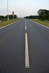Fototapeta premium Photo of dark asphalted road and metall barrier