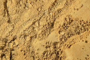 Closeup of yellow sand pile texture background.