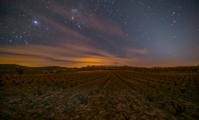 long exposure photo during the night with clouds in motion and star trails in the sky - Image