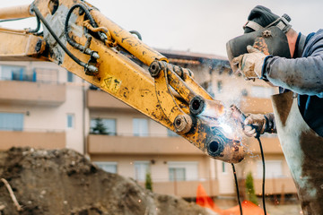 Close up of mechanic fixing excavator on construction site © aboutmomentsimages