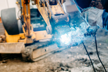Close up of welder on construction site. Repair welding is done on machinery - Powered by Adobe