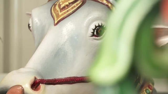 Handheld, close up shot of a statue of the bull Nandi, licking its lips.
