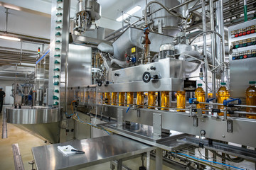 Conveyor belt or line in beverage plant with modern industrial machine equipment. Plastic bottles...