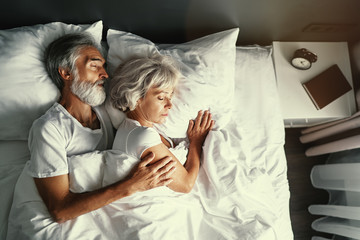 Senior family couple sleeping together in bed.