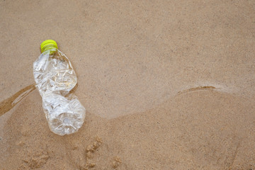 Plastic water bottles pollution in ocean, cleaning on the beach, volunteer concept. Environmental...