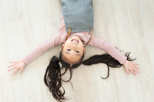 girl lying on wooden floor.