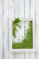 Green peas on a white wooden background. Top view, close-up