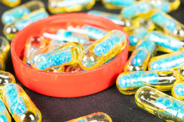 Gelatin capsules with the medicine are scattered across the table.