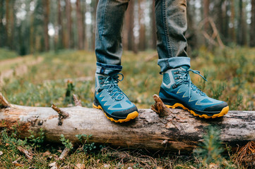 Male legs wearing sportive hiking shoes outdoor. Mens legs in trekking boots for outdoor activity