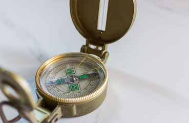 Metal compass on white marble table