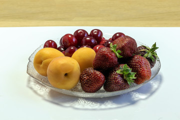 Fruit dessert of apricot,cherry and strawberry on the village table.