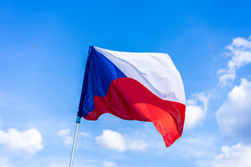 The national flag of Czech republic. National flag of Czechia. Close up shot of a flag on a blue  sky background. Czech flag waving in the wind.