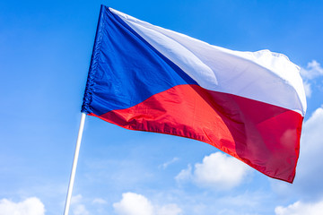 Naklejka na ściany i meble The national flag of Czech republic. National flag of Czechia. Close up shot of a flag on a blue sky background. Czech flag waving in the wind.