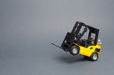 Yellow forklift truck rides on the rear wheels on gray background. Warehouse equipment, vehicle....