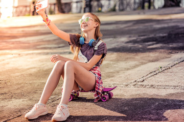 Laughing good-looking little lady making selfie on a smartphone