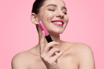 Smiling woman showing liquid lipstick