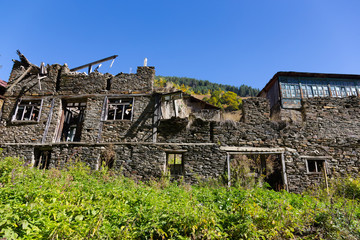Fototapeta na wymiar Old ruined stone house. Autumn mountain landscape in Svaneti. Georgia