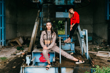 Stylish female couple posing at abandoned cableway station