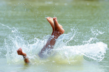 Asian children feet  jumping into the water.