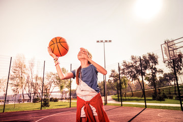 Experienced long-haired girl actively throwing orange ball