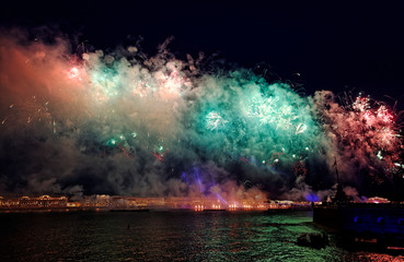 Fototapeta na wymiar Fireworks over the water Holiday light. Night cityscape scene. Neva river, Saint-Petersburg, Russia. Holiday Scarlet Sails.