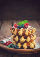 Belgian waffles with berry fruits and sprinkled with sugar