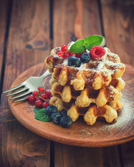 Belgian waffles with berry fruits and sprinkled with sugar