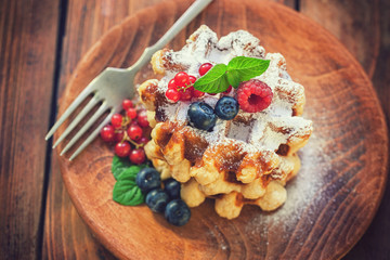 Belgian waffles with berry fruits and sprinkled with sugar