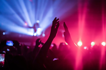 silhouettes of concert crowd in front of bright stage lights