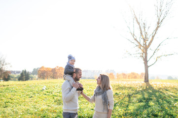 Happy family outdoor activity. Young emotional parents playing with their child in sunny day.