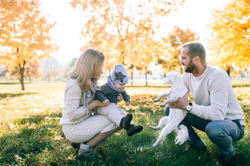 Fototapeta premium Happy family outdoor activity. Young couple playing with their child in autumn park.