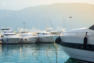 Yacht on the background of boat port and mountain in the sun. Summer, sea, travel, luxury vacation...