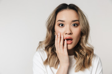 Fototapeta premium Shocked emotional cute young woman posing isolated over white wall background.