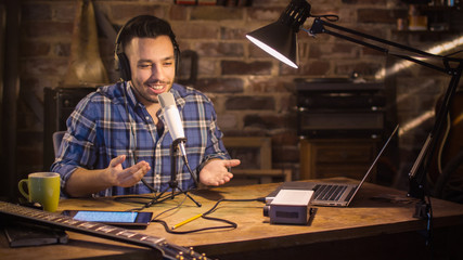 Young man makes a podcast audio recording at home in a garage. - obrazy, fototapety, plakaty