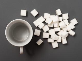 refined sugar lump white and white cup on a gray background