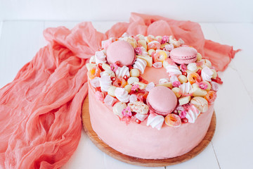 Pink cake. Decoration from sweets, macarons, marshmallows, white chocolate. Sweet birthday present. For girl.