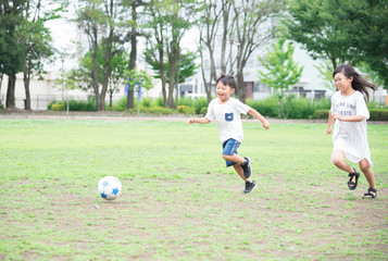公園でサッカーをする子供