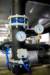 The equipment of the boiler-house, valves, tubes, pressure gauges, thermometer. Close up of manometer, pipe, flow meter, water pumps and valves of heating system in a boiler room