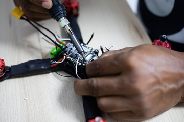 Hands soldering a racing drone