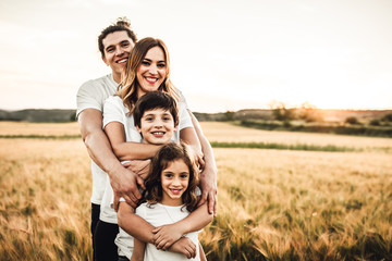 Portrait of a happy young family smiling in the countryside. Concept of family fun in nature.