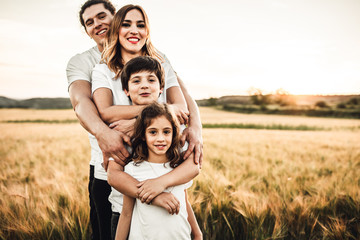 Portrait of a happy young family smiling in the countryside. Concept of family fun in nature.